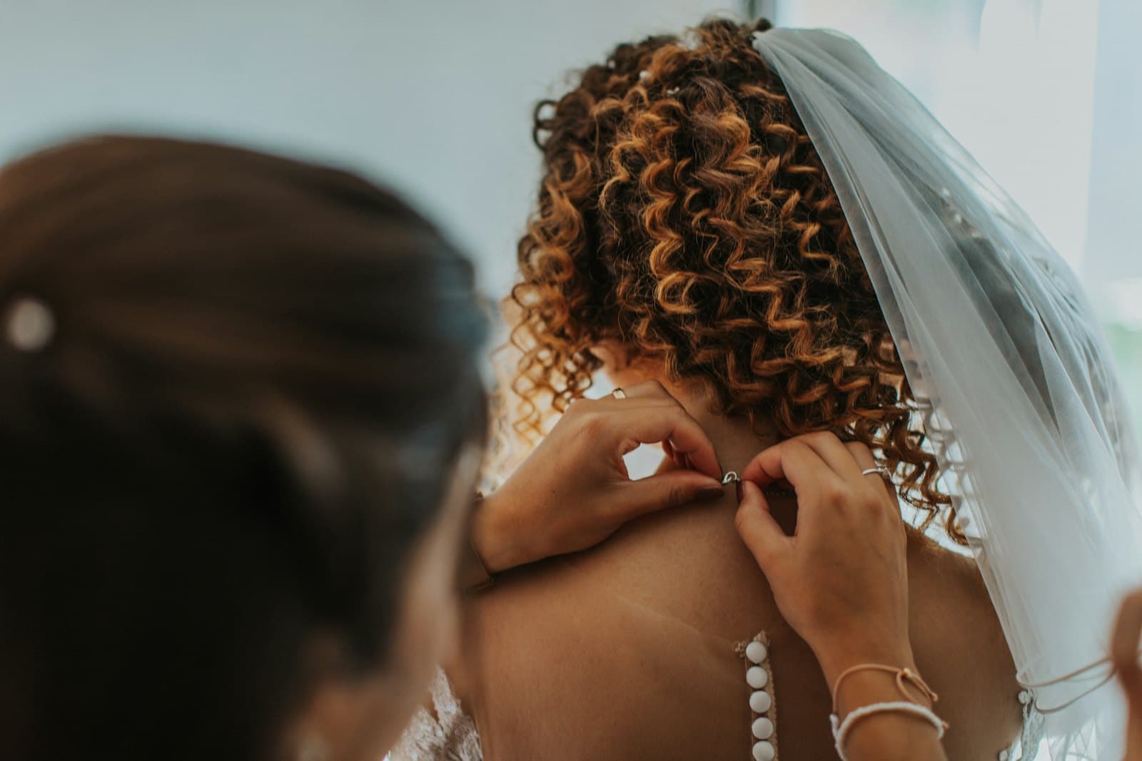 Novia preparándose con ayuda el día de su boda